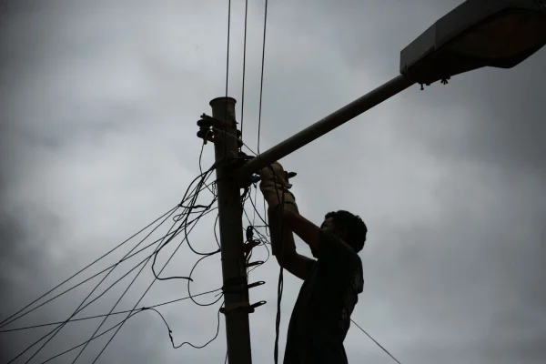 Homem conserta poste de eletricidade, no DF