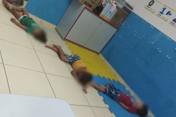 imagem colorida mostra crianças deitadas em chão de sala - metrópoles