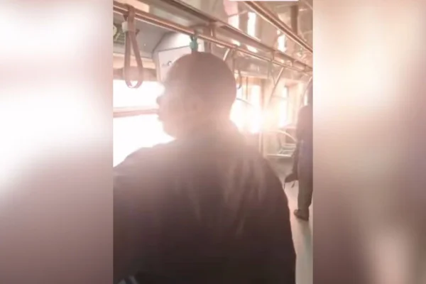 Imagens coloridas mostram homem com casaco escuro dentro de vagão de trem e um clarão do lado de fora provocado por incêndio na estação