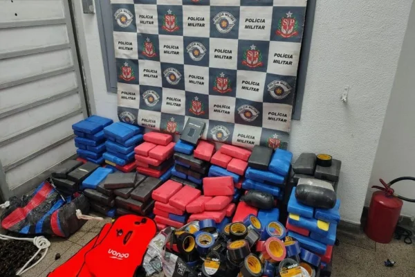 Imagem colorida mostra policiais militares (PMs) abrindo pacotes de cocaína encontrados no litoral de SP - Metrópoles