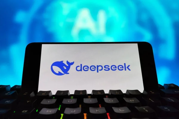 Imagem de telefone celular, colocado sobre o teclado de um computador, exibindo o logotipo da startup chinesa DeepSeek - Metrópoles