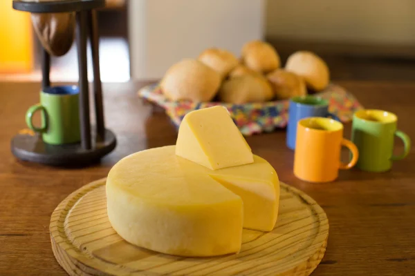 Fotografia colorida mostrando queijo cortado em mesa-Metrópoles