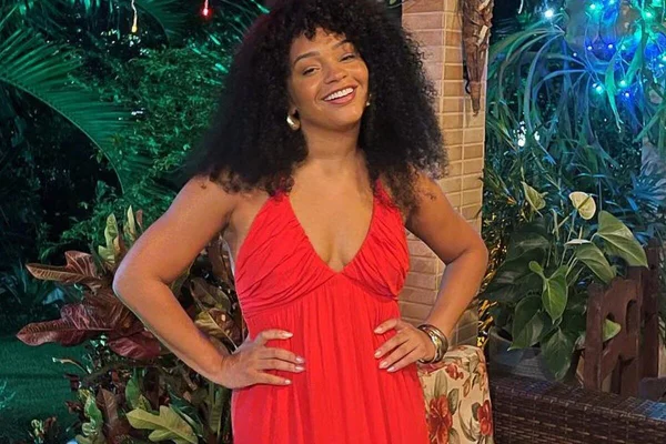 Juliana Alves posa de vestido vermelho, com os cabelos soltos e as mãos na cintura - Metrópoles