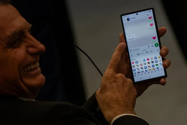 imagem colorida de Jair Bolsonaro mostrando o celular com mensgans de Michelle, no STF