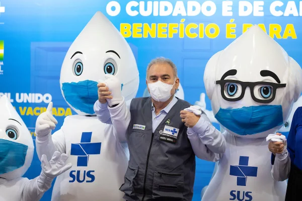 ministro da saúde marcelo queiroga de mãos dadas a mascote zé gotinha