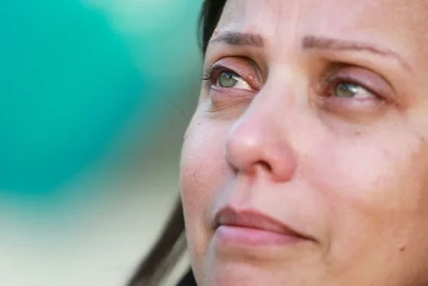 Mulher olha para cima com lágrimas nos olhos