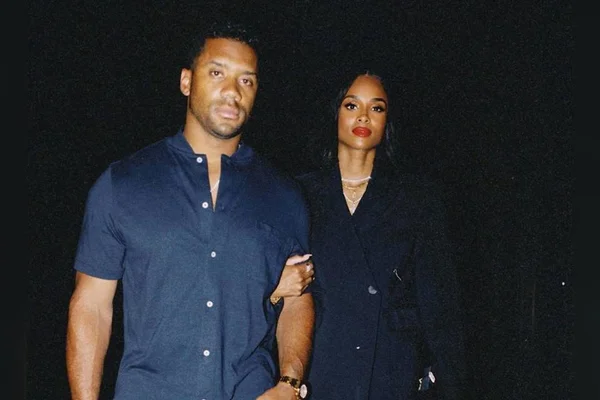 Foto colorida de Russell Wilson de braços dados - Metrópoles
