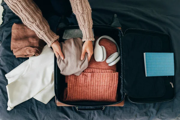 Mãos de mulher arrumando mala para viajar - Metrópoles