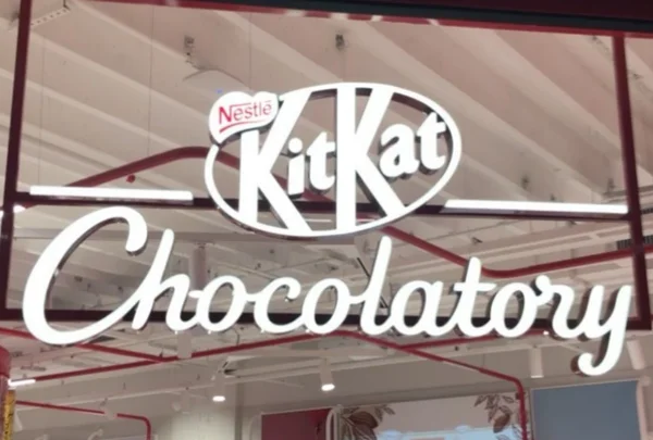 Logotipos da Nestlé e da KitKat, na cor branca, estampando entrada da loja KitKat Chocolatory