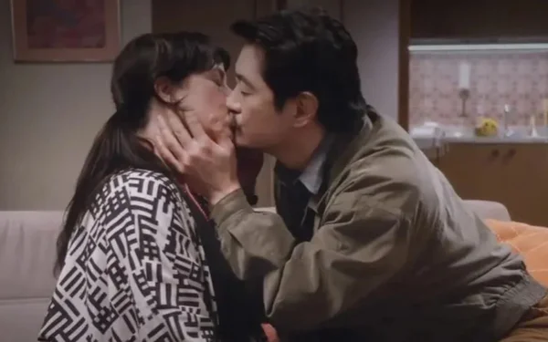 Um homem e uma mulher se beijando em um sofá - Metrópoles
