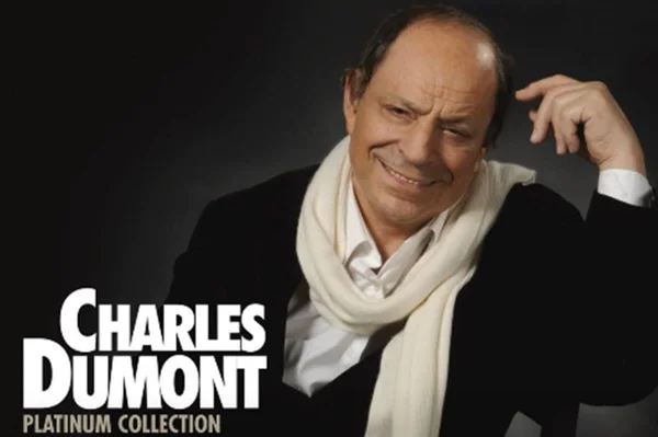 Imagem colorida de Charles Dumont em capa de álbum, usando roupa preta e cachecol branco - Metrópoles