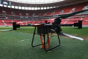 Na dinâmica, um drone lançou uma substância desconhecida sobre a arquibancada, provocando tumulto, contaminação de múltiplas vítimas e a necessidade de acionamento imediato das forças de segurança e resgate
