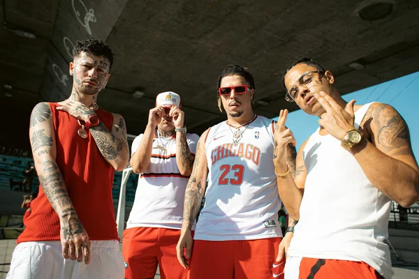 Foto do artista WC no Beat com camisa branca e o número 23, acompanhado do grupo UCLÃ, formado pelos outros três homens da foto - Metrópoles