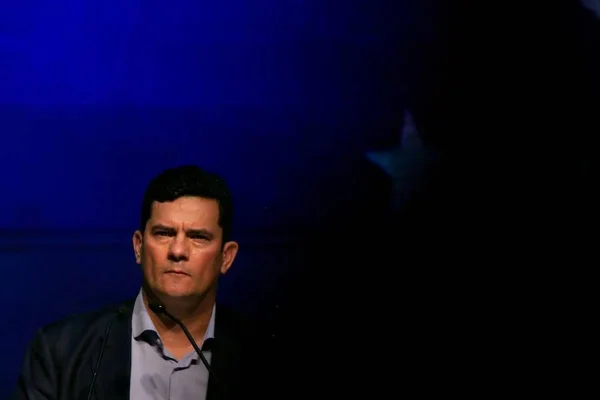 O ex-juiz Sérgio Moro diante de microfone fala em evento sob fundo azul. Ele desistiu da candidatura à presidência - Metrópoles