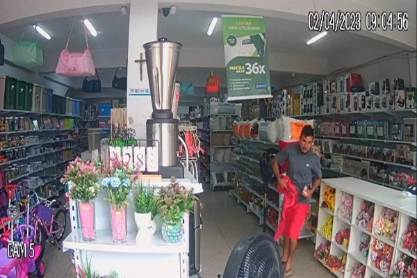 Câmeras de segurança capturam imagens de homem de blusa cinza e bermuda laranja em loja