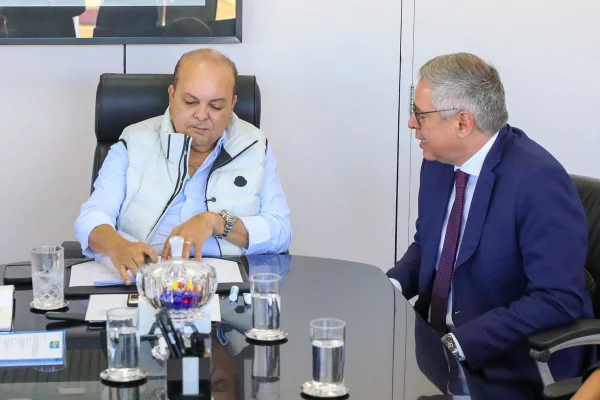 Dois homens sentados em volta de uma mesa