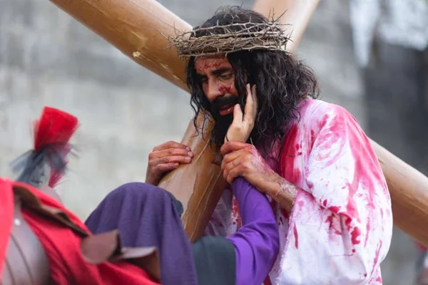 mulher coloca a mão no rosto de Jesus