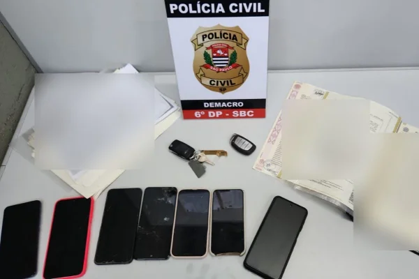 Imagem colorida mostra celulares e documentos apreendidos com grupo suspeito de aplicar o golpe da falsa venda de imóveis em São Paulo - Metrópoles