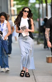Anne Hathaway usando saia jeans e calçados Birkenstock durante as filmagens de O Diabo Veste Prada 2