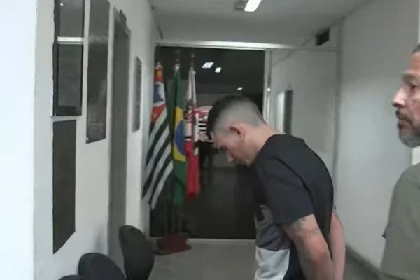 Imagem colorida mostra Douglas Alves da Silva chegando em delegacia após audiência de custódia - Metrópoles