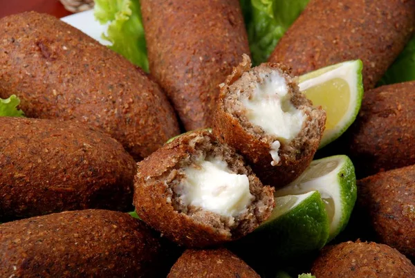 Foto colorida em close de um prato de quibes fritos recheados com queijo em um prato com alface e rodelas de limão - Metrópoles