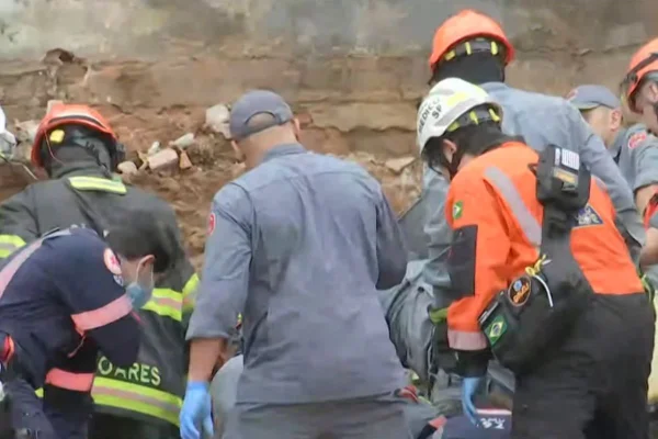 Imagem colorida mostra bombeiros em resgate de desmoronamento. Metrópoles
