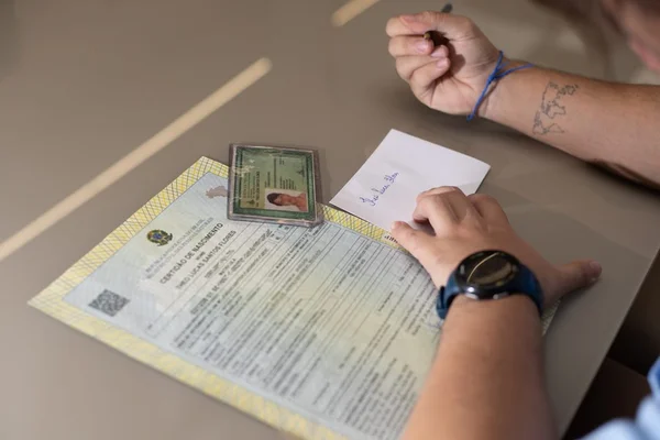 certidão de nascimento ao lado de identidade