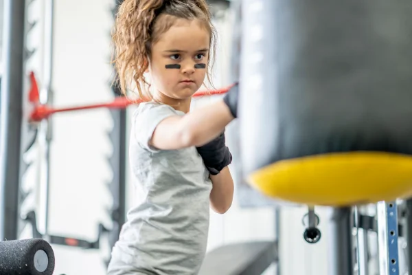 Menina de 7 anos tendo aulas de boxe em um centro de treinamento como forma de exercício e defesa pessoal - Metrópoles - atividade física para ciranças