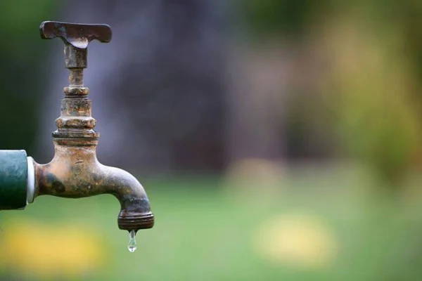 Imagem colorida de torneira com gota de água saindo - Metrópoles