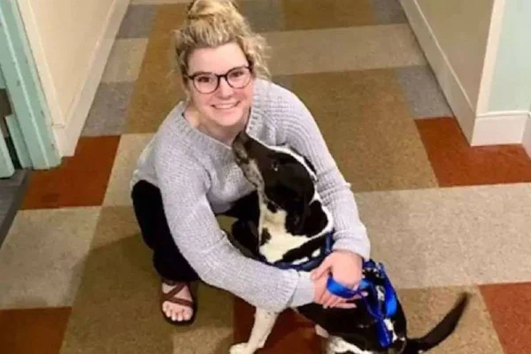 foto de mulher abraçada em cachorro malhado preto e branco