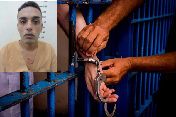 Imagem colorida de grades azuis de cadeia, com duas mãos algemando outra mão. Na lateral esquerda, acima, homem de cabelo curto, sem barba, com roupa de presidiário