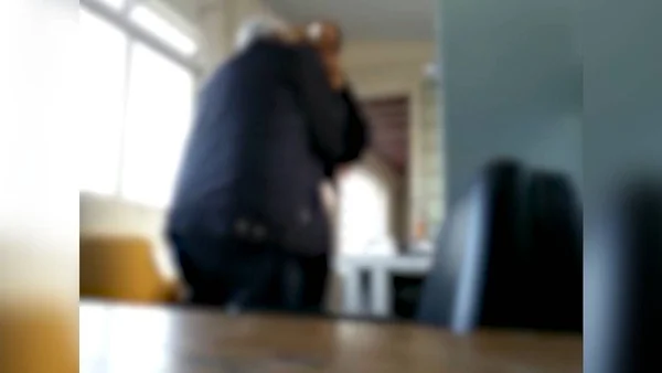 Iamgem morrada mostra o pastor junto a uma mulher na repartição municipal