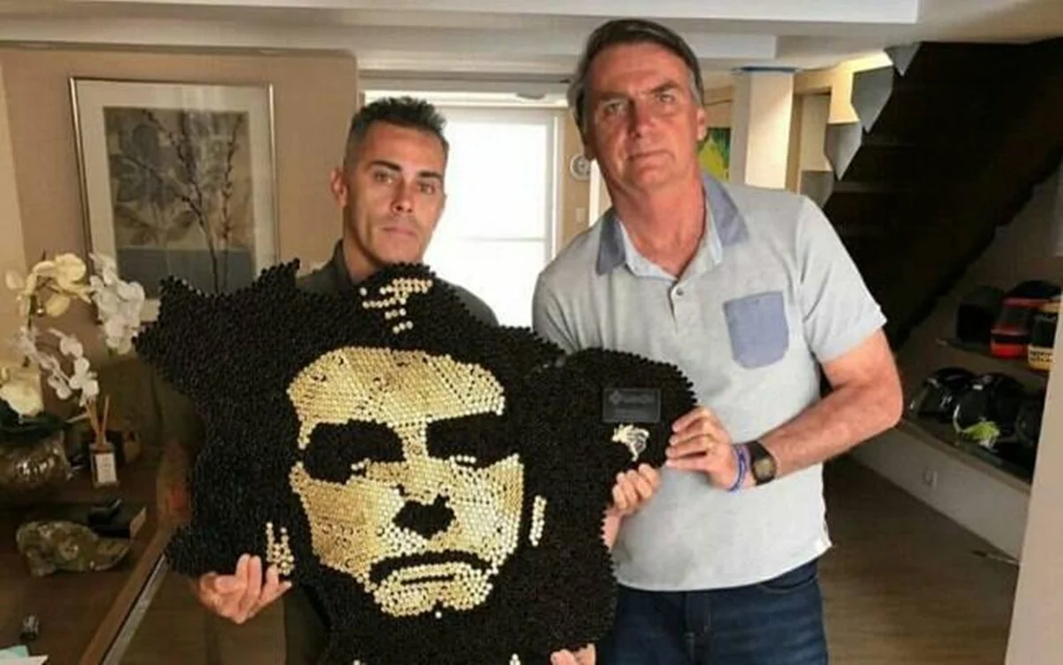 Artista entregando obra a Bolsonaro
