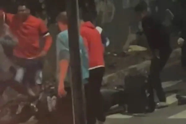 Imagens coloridas mostram pessoas durante protesto em volta de moto tombada no asfalto