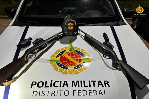 Foto colorida de carro da PM com espingardas