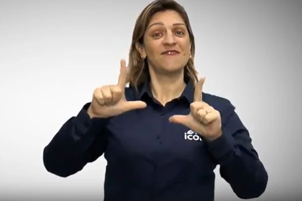 Imagem colorida mostra mulher em frente a fundo branco. Ela tem cabelos loiros na altura dos ombros. Ela veste camisa azul marinho e faz movimento com as mãos - Metrópoles