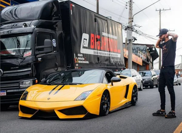 lamborghini amarela ao lado de caminhão