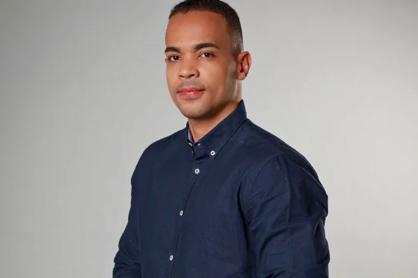Homem negro com cabelos curtos veste camisa azul marinho - Metrópoles