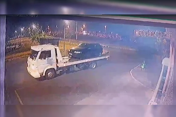 Imagem colorida de um caminhão-guincho branco levando um carro preto