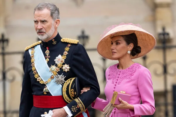 Foto colorida de homem idoso, com trajes militares, ao lado de mulher parda com roupa e chapéu cor-de-rosa - Metrópoles