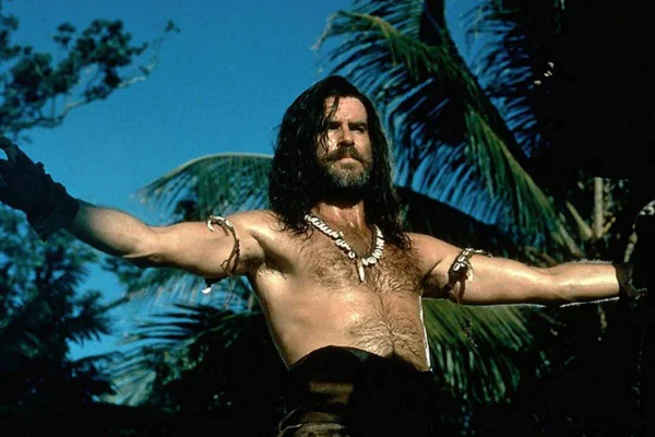 foto colorida de homem branco de cabelos longos sem camisa com braços abertos - metrópoles