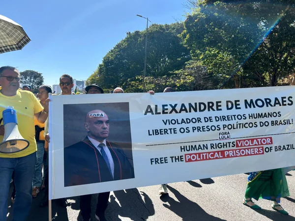 Imagem colorida de Sebastião Coelho segurando um cartaz contra Moraes