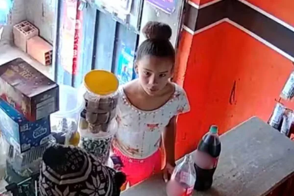 Imagem colorida de menina parda, com cabelo preso em coque, em balcão de venda - Metrópoles