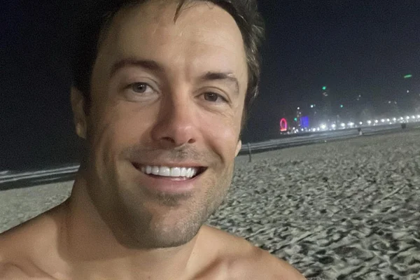 Kayky Brito posa, sorridente, na praia - Metrópoles