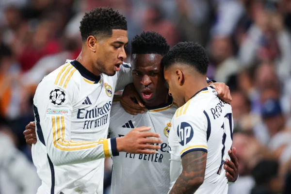 Imagem colorida de Bellingham, Vinícius Júnior e Rodrygo abraçados- Metrópoles