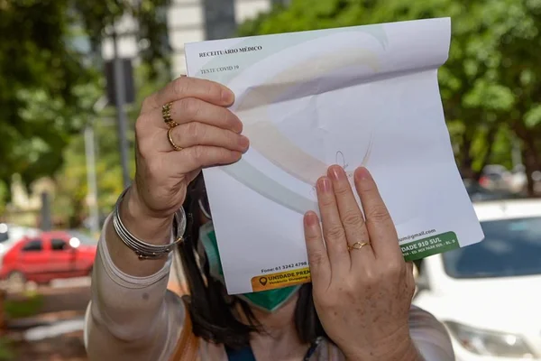 Paciente esconde o rosto depois de ter pedido de teste para coronavírus negado no Hospital Regional da Asa Norte (Hran)