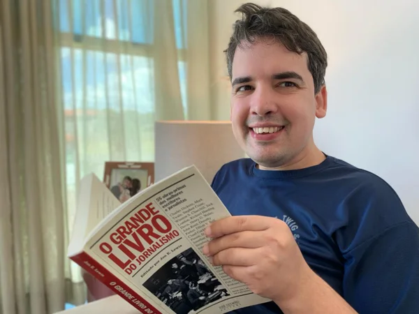 Na foto, Bernardo segura um livro e sorri