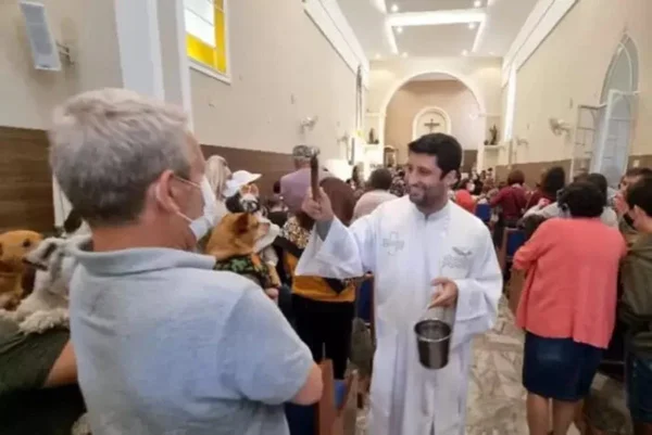 Imagem colorida de cachorro sendo abençoado na Igreja Católica - Metrópoles