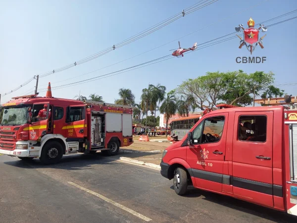 Imagem colorida de uma van e uma viatura do CBMDF, além de uma aeronave sobrevoando os dois veículos