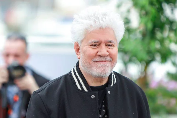 Foto colorida de Pedro Almodovar com casaco preto e meio sorriso - Metrópoles